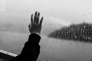 hand on the window in the raining day