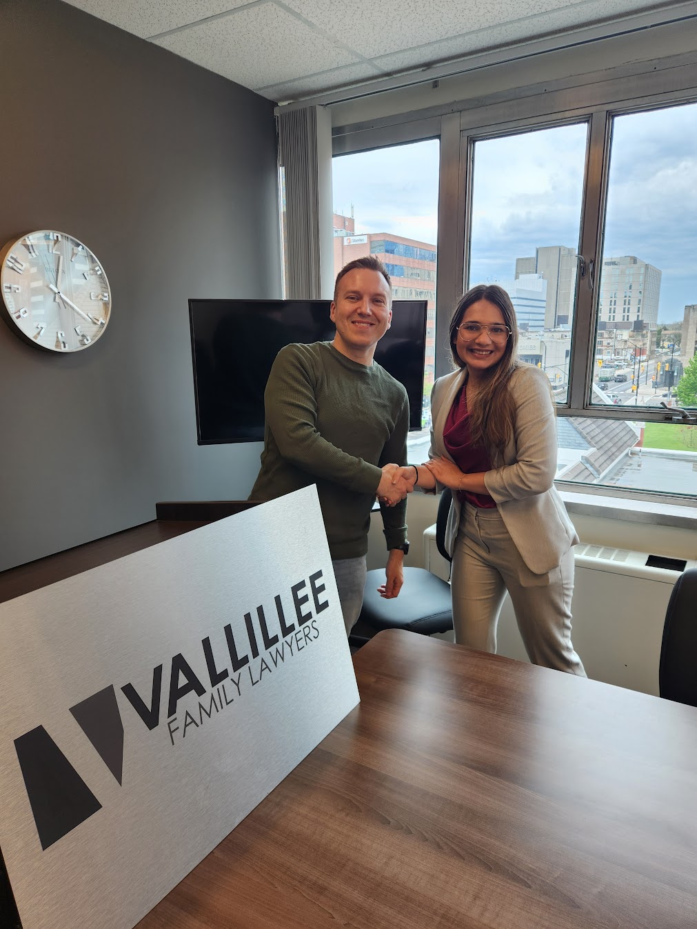Fiza Sharma and Eric Vallillee shaking hands at Vallillee Family Lawyers in London, Ontario on her last day of articles.